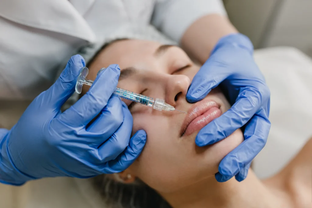 closeup-portrait-young-woman-doing-botox-procedures-by-professional-injection-making-lips-modern-devices-technology-medicine-cosmetology-therapy | Solace Aesthetics and Wellness